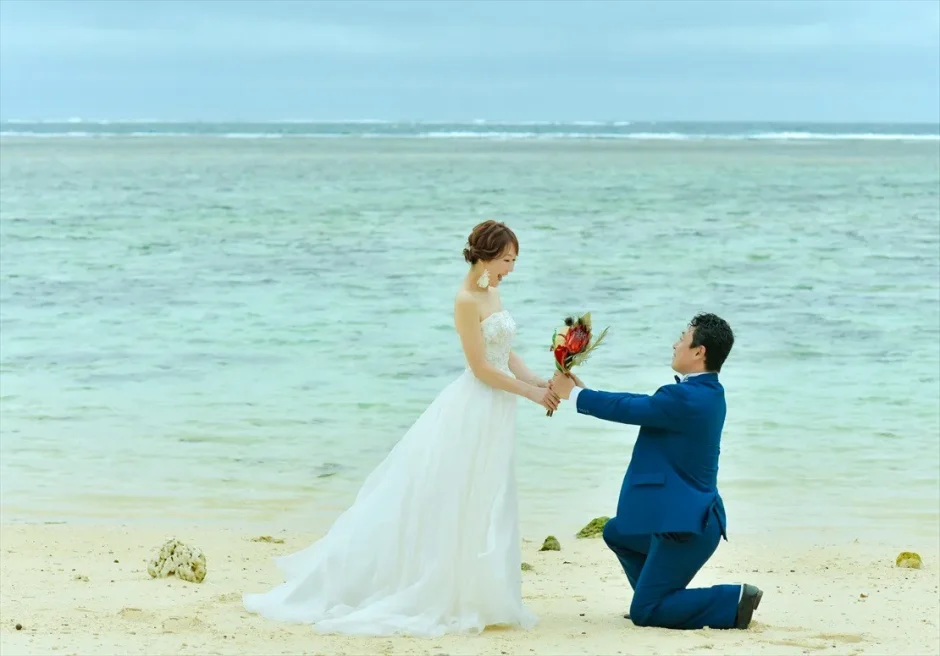 コーラルテラス石垣島のビーチでプロポーズ風に膝をつく新郎