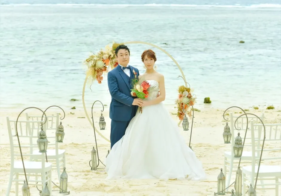コーラルテラス石垣島のビーチ挙式アーチ前に立つ新郎新婦