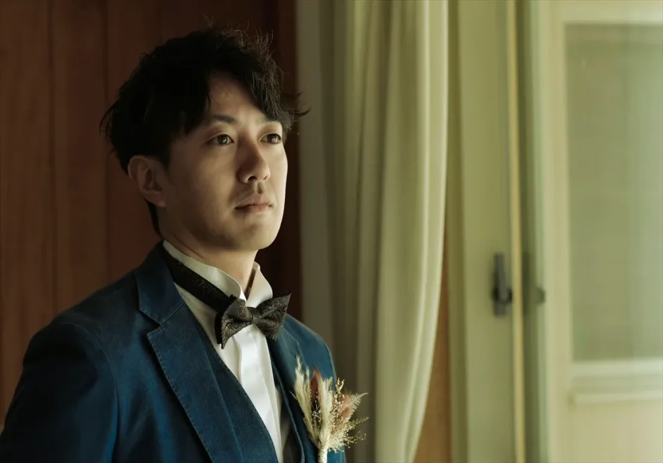 コーラルテラス石垣島の二人挙式前、新郎が支度を整え窓辺に立つ前撮りフォトウェディング